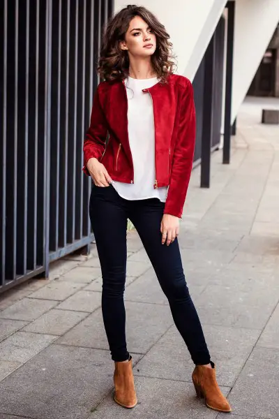 A woman wears jeans with brown suede boots, white t shirt and red coat