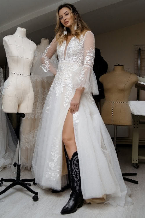 a woman wears black cowboy boots with a wedding dress
