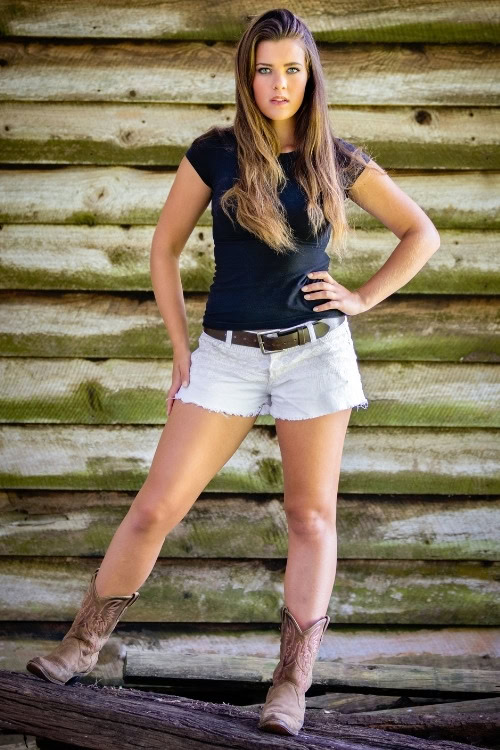 a woman wears brown cowboy boots with white shorts and T shirt