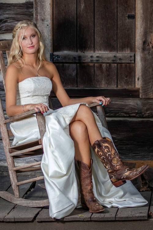 a woman wears brown cowboy boots with white wedding dress siting on a chair