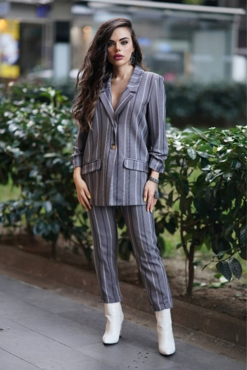 a woman wears white cowboy boots with striped suit set