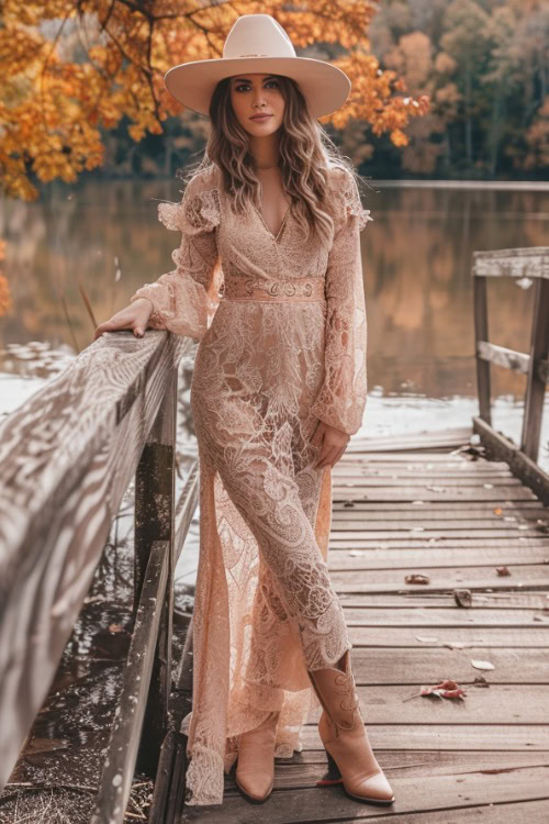 a woman wears a blush lace maxi dress and cowboy boots