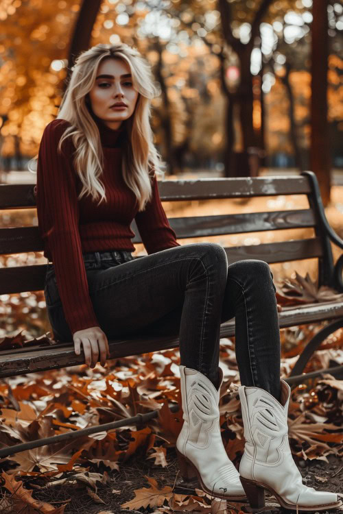 A woman wears short white cowboy boots with a fitted turtleneck sweater