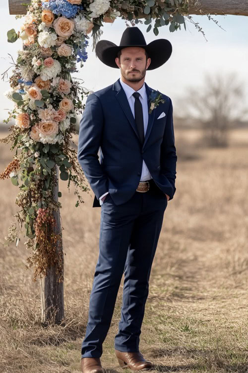 A groomsman wears a navy suit with brown cowboy boots and a black cowboy hat (2)