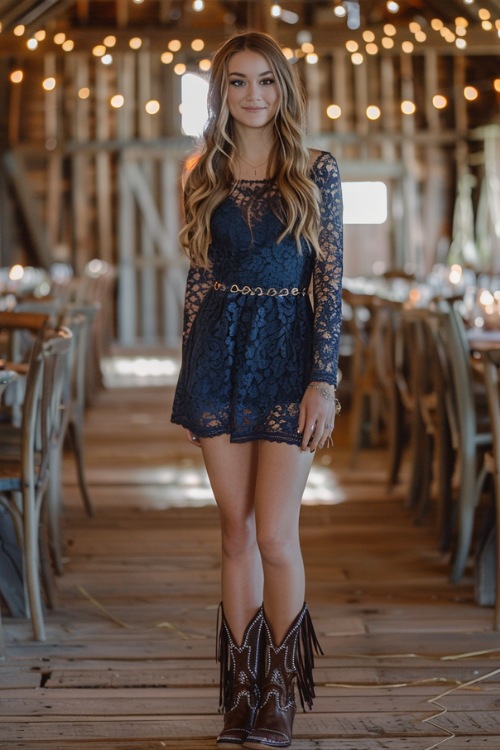 a woman wears a navy lace dress, and brown fringe cowboy boots