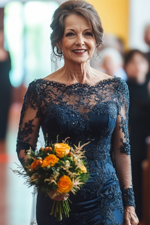 A woman over 50 wears a navy blue lace wedding guest dress with long sleeves