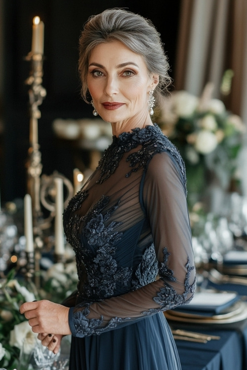 A woman over 50 wears a navy blue wedding guest dress with sheer lace bodice and sleeves