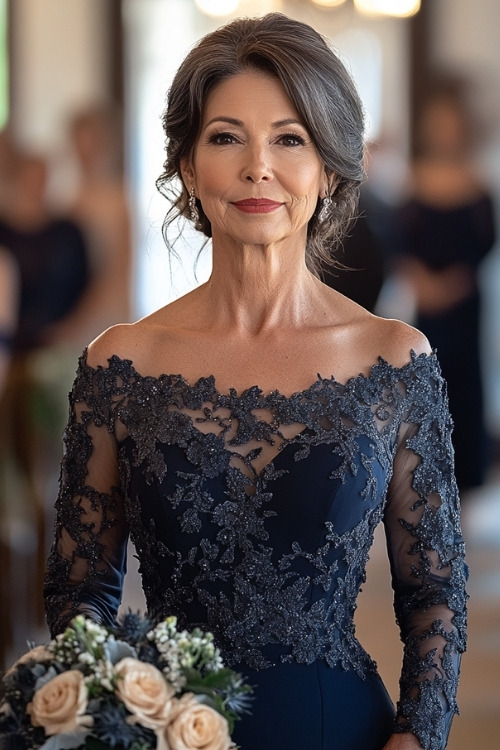 A woman over 50 wears a navy off the shoulder lace wedding guest dress