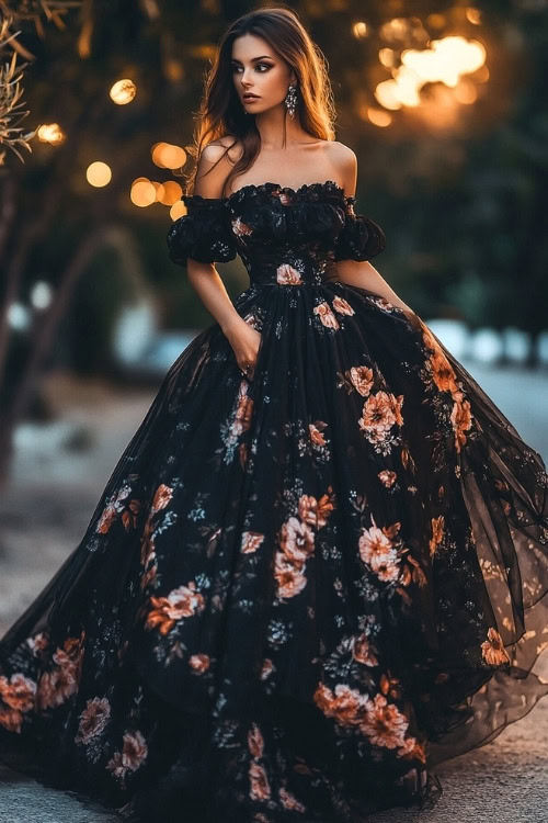 A woman wears a black floral wedding guest gown with an off shoulder design