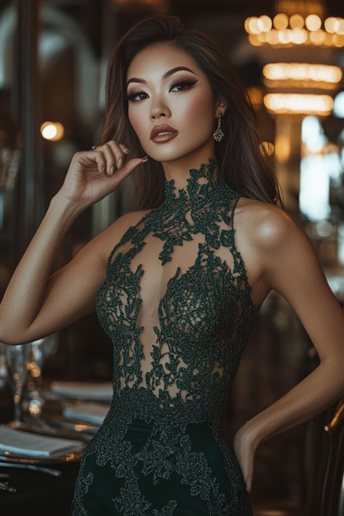 A woman wears a halter dark green wedding guest dress with a sheer bodice