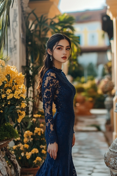 a woman wears a navy blue lace wedding guest dress with long sleeves