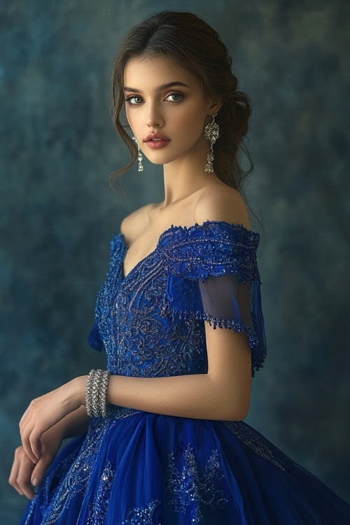 A woman in a royal blue gown with a square neckline and delicate embroidery, accessorized with a silver bracelet and earrings