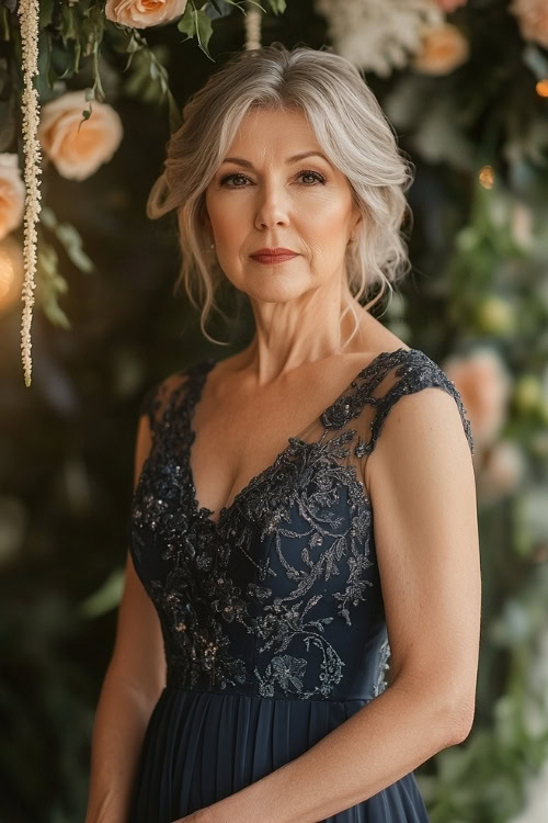 A fashionable woman over 50 in a navy tea-length midi dress with lace embroidery, a sweetheart neckline, and subtle pleats