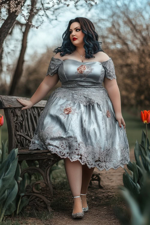 A stylish plus-size woman in a metallic silver knee-length dress with short puff sleeves, floral lace embroidery, and a tulip hemline