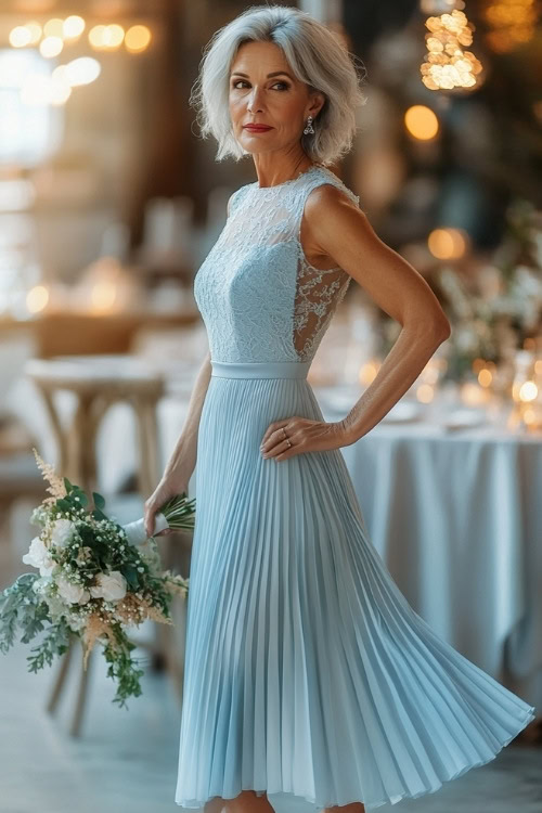 A stylish woman over 50 in a pastel blue sleeveless midi dress with a pleated hemline, lace accents, and a flowing bodice (2)