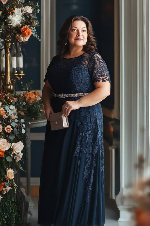 A plus-size woman over 50 in a sophisticated navy blue midi dress with lace overlay and cap sleeves, paired with a satin belt