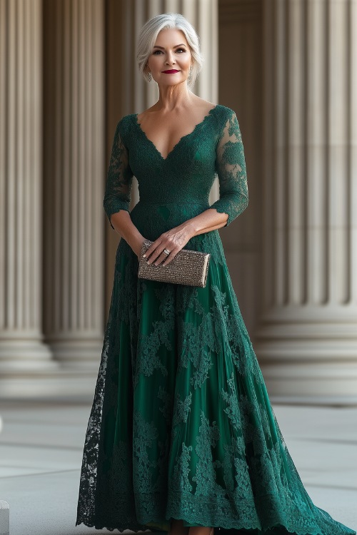 A woman over 50 in a deep emerald green A-line gown with three-quarter lace sleeves and a V-neckline